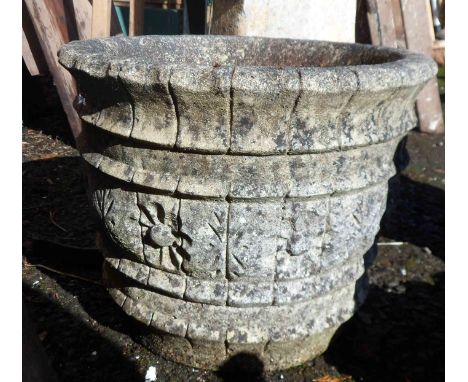 A concrete garden planter of circular form with a central frieze depicting flowerheads