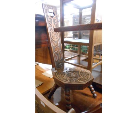 An Anglo-Indian carved hardwood bobbin turned spinning chair with decorative back and representation of Ganesh to seat panel