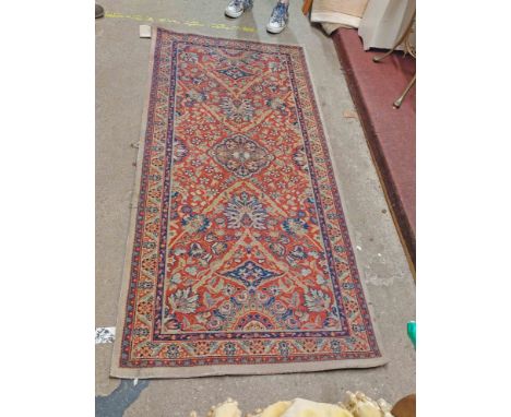A machine made runner with central medallion surrounded by flowerhead decoration and floral border