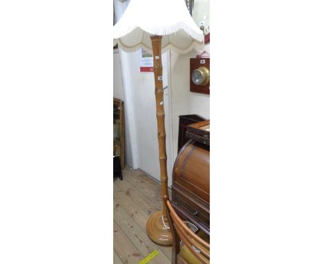 A vintage simulated bamboo standard lamp with shade, set on a stepped circular base