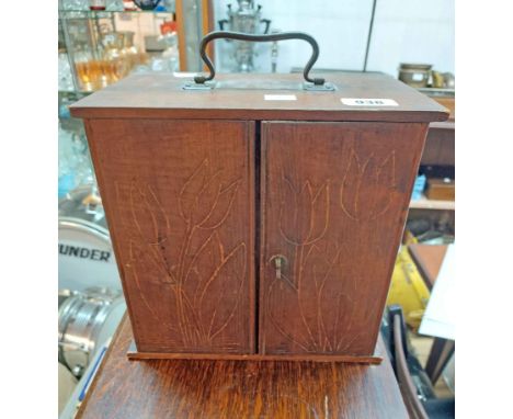 A 19th Century stained pine collector's chest with four graduated drawers enclosed by panel doors with decorative carved tuli