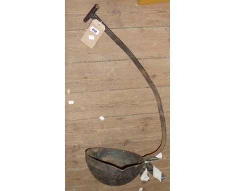 A large wrought iron smelting ladle, the handle of curved form for hanging