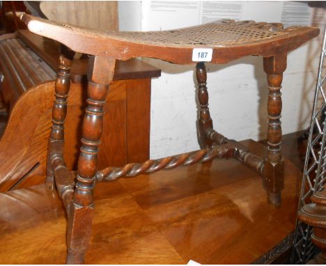 A mahogany dressing stool with curved seat and woven rattan panel, set on barley twist supports - wear