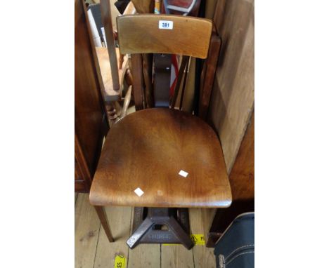 A vintage Singer sewing chair with curved back rail and bentwood seat panel, set on a heavy cast iron pillar base with brandi