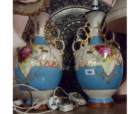 A pair of large ceramic table lamps of two handled urn form with decorative transfer printed and painted rose gilt framed pan