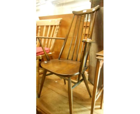 A mid-Century Ercol elm stick-back elbow chair with solid moulded seat, set on tapered supports - with original label