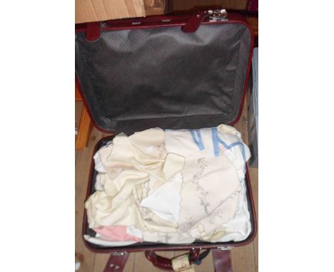 A suitcase containing a quantity of table linen including tray cloths, runners, etc.