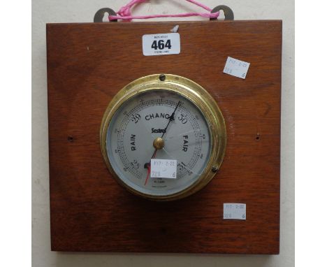 A 10cm diameter vintage 'Sestrel' brass cased bulkhead barometer (glass damaged), mounted on a wooden plaque