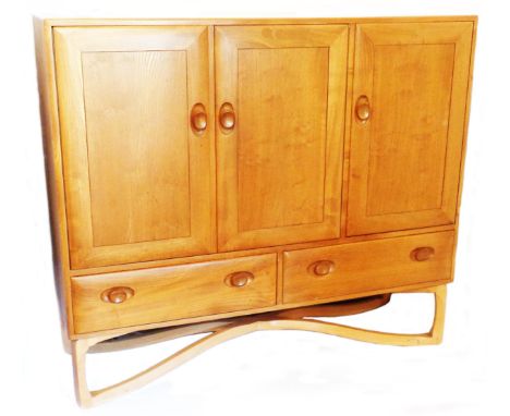 A 1.3m retro Ercol light elm sideboard with slides and shelves enclosed by two doors and a further door enclosing glass shelv