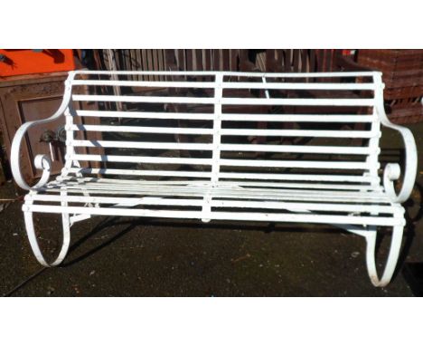 An antique wrought iron two seater garden bench with scroll arms and metal slatted seat