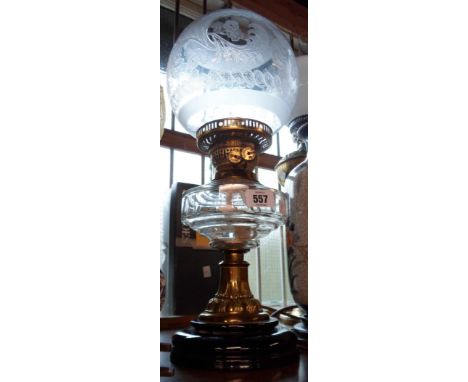 A Victorian oil lamp with cut sided glass reservoir, brass pedestal stem and opaque ceramic foot - with chimney and etched gl