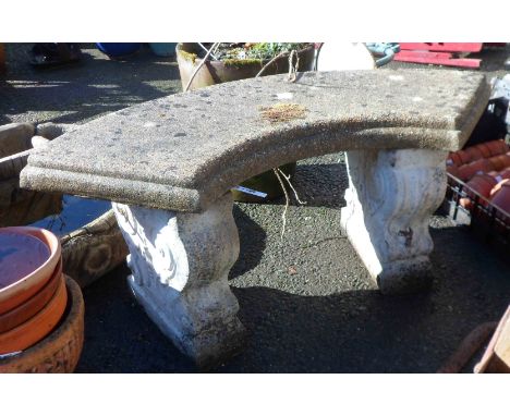 A concrete three section curved garden bench with classical form uprights