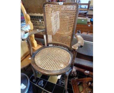 A vintage stained beech famed elbow chair with rattan back and seat panels