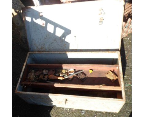 An old metal lift-top tool trunk containing a quantity of old tools