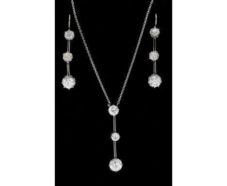 A diamond and 18ct white gold drop pendant and earring suite, the pendant comprising an articulated bar with three graduated 