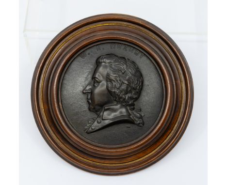 A Victorian bois durci portrait relief rondel depicting Wolfgang Amadeus Mozart, mounted in a mahogany circular frame, overal