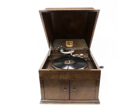 A His Masters Voice, (HMV) wooden cased record player, with lift up cover revealing area for records and underneath with two 