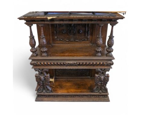 An 18th century carved oak three tier buffet, the base with plinth carved with foliate design and ribbed edging; upon two orn