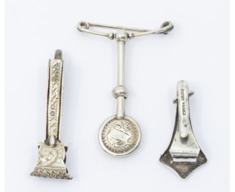 Three Victorian or later silver napkin clips comprising: a late Victorian example with engraved and chased design, hallmarked