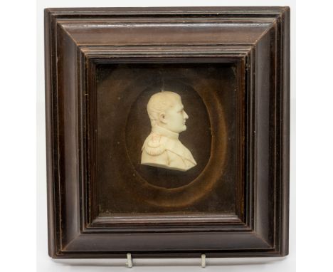 A 19th century wax relief portrait of Napoleon Bonaparte, in tunic facing right, encased in cushioned area within a glazed ma