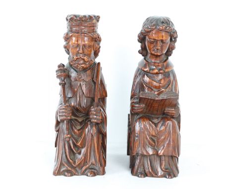 A CHARMING PAIR OF 19TH CENTURY PITCH PINE PEW END FIGURES (2). The first carved as a bearded king seated on a throne, 28cm h