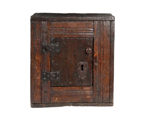 A CHARLES II OAK JOINED AND BOARDED TABLE BOX/CUPBOARD, CIRCA 1670. Having a single plain panelled door enclosing a single sh