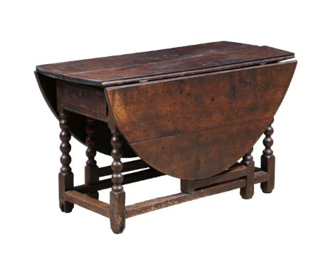 AN 18TH CENTURY OAK GATELEG TABLE. With D shaped drop leaves and end drawer, raised on bobbin turned legs and chamfered stret
