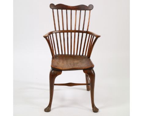 A GEORGE III OAK AND ELM COMB-BACK CHAIR, WEST COUNTRY. The shaped top rail above a spindle back and shaped solid seat raised