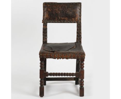 A CHARLES II OAK AND LEATHER SIDE CHAIR, CIRCA 1670-80. having a leather upholstered back and seat with iron studs raised on 