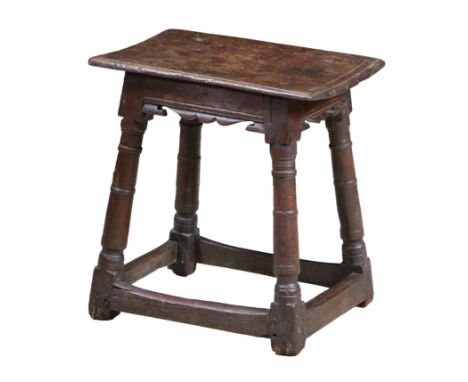 A CHARLES I OAK JOINT STOOL, CIRCA 1640, NORTH COUNTRY. The rectangular top above a fret carved frieze and gun barrel turned 