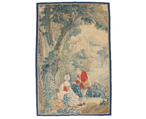 AN 18TH CENTURY FRENCH WALL HANGING TAPESTRY. A couple under a large tree with a dog resting to the ladies side as the gentle