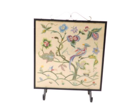 A 20thC iron fire screen, with embroidered centre, on scroll feet, 76cm high.