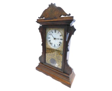 A late 19thC American mantel clock, in a carved and engraved walnut case, with white paper dial, verre eglomise door decorate