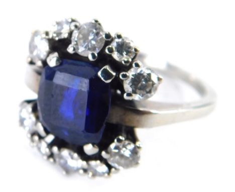 A sapphire and diamond dress ring, rectangular cut sapphire in four claw setting approx 0.35ct, flanked by an arrangement of 