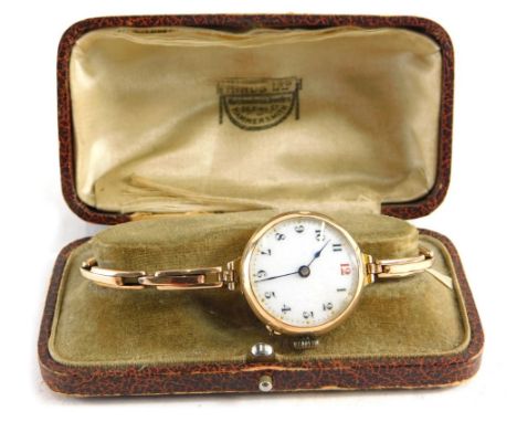 An early 20thC wristwatch, with 3cm diameter Arabic enamel dial in an unmarked 9ct gold case, with elasticated bracelet, in f