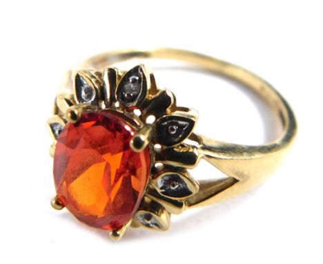 A 9ct gold topaz and diamond floral cluster ring, with central oval orange topaz, surrounded by tiny diamonds, on V splayed s