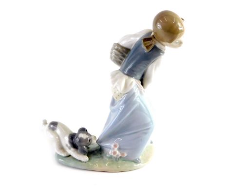 A Lladro figure of a girl, holding basket being attacked by puppy, number 66 Q-27E, printed and impressed marks beneath, 20cm