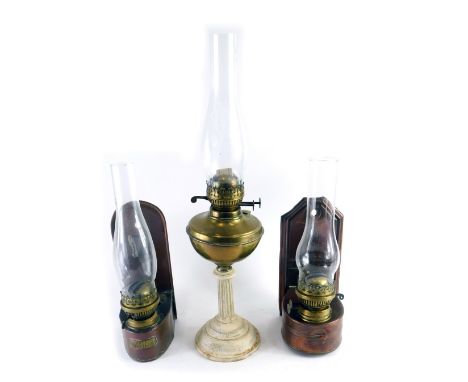 A brass table lamp, with clear glass funnel, brass reservoir and classical column stem, 60cm high, and two copper hanging wal