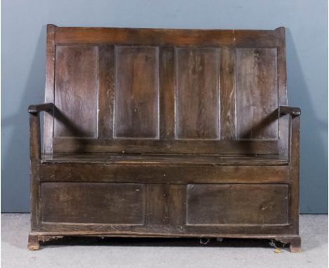 An 18th Century panelled oak box settle with four panels to back, the box seat with lifting lid (hinges loose) and with two p