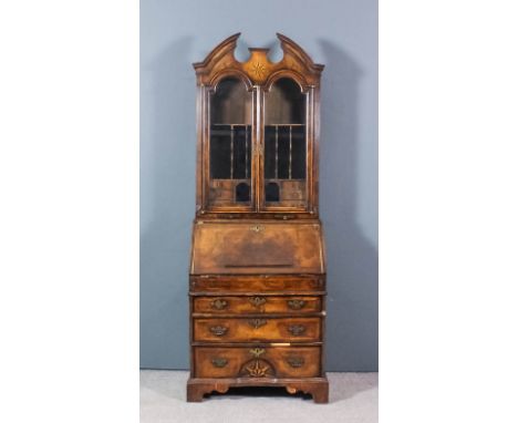 A walnut bureau bookcase of "early 18th Century" design, inlaid with star motifs, the upper part with shaped and moulded pedi