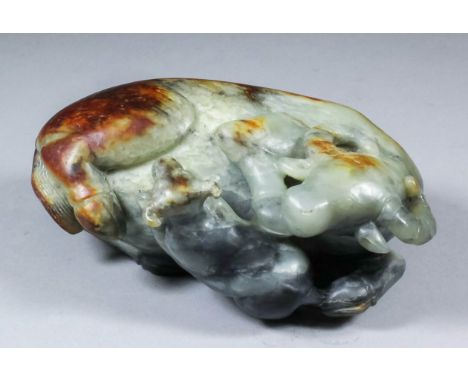 A Chinese celadon jade carving, with brown inclusions, of recumbent water buffalo and calf, 2.5ins (6.3cm) high (20th Century
