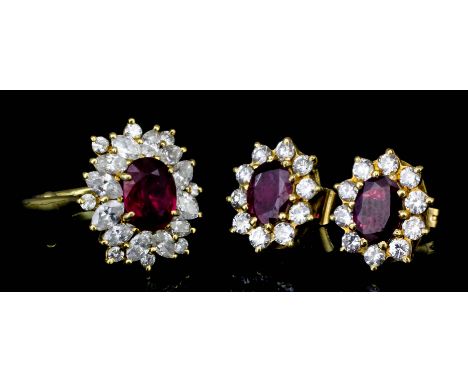 A modern Continental 18k gold mounted ruby and diamond oval cluster ring set with a central ruby (approximately 1ct) surround