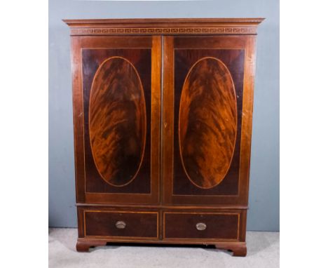 An Edwardian mahogany wardrobe inlaid with satinwood bandings and chequered stringings, with moulded cornice enclosed by a pa