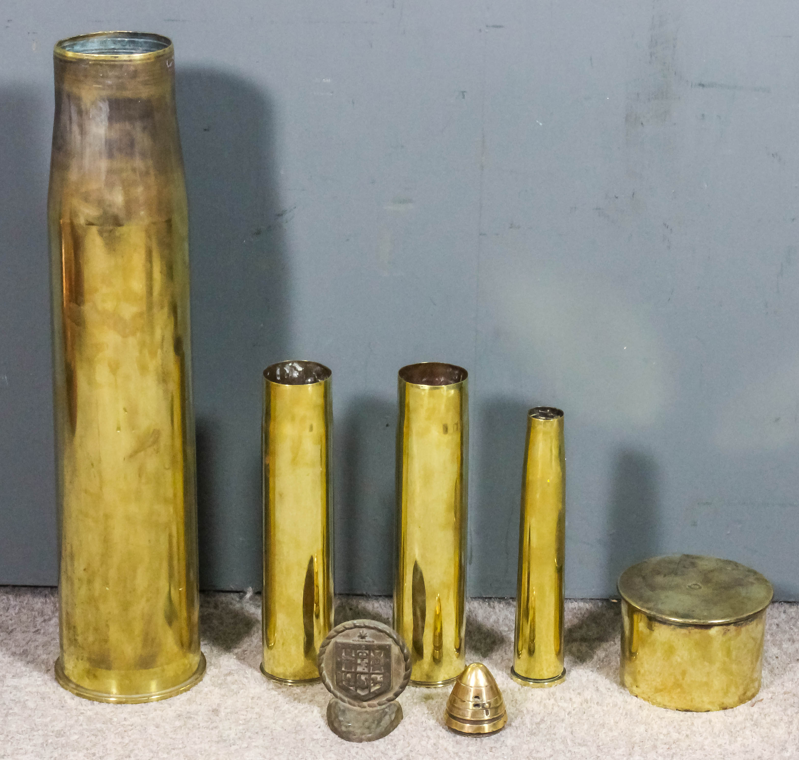 A large brass shell case, 28ins high, together with four other brass
