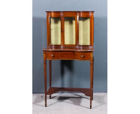 An Edwardian mahogany bow and breakfront display cabinet on stand, inlaid with boxwood stringings, the upper part with moulde