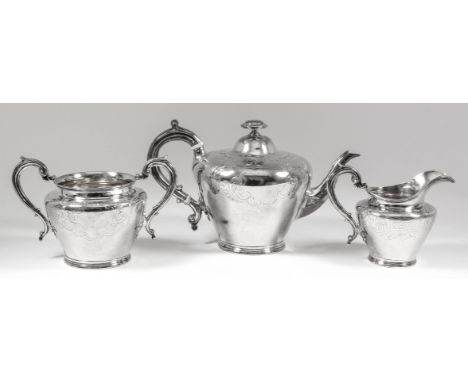 A Victorian silver three piece tea service of cylindrical tapered form, engraved with scroll, leaf and trellis ornament, comp