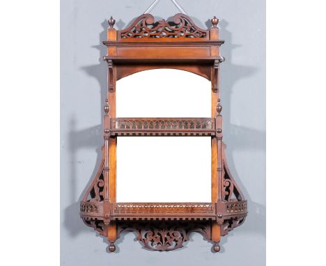 A late Victorian walnut three tier display shelf with bevelled mirror panel to back, two lower shelves, fretted gallery and t