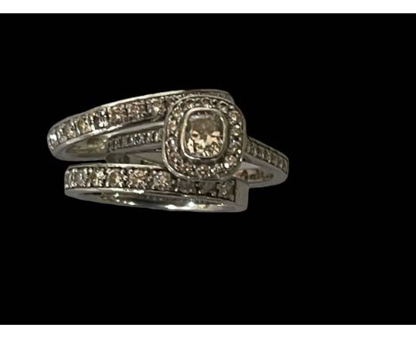 Diamond platinum trio of rings with cluster ring having cushion diamond bordered with brilliants and two eternity rings, size