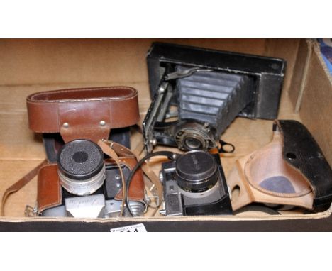 Three vintage cameras comprising Zenit 3m, Konica ee-matic both with leather cases and a Kodak no 2-c folding autographic cam