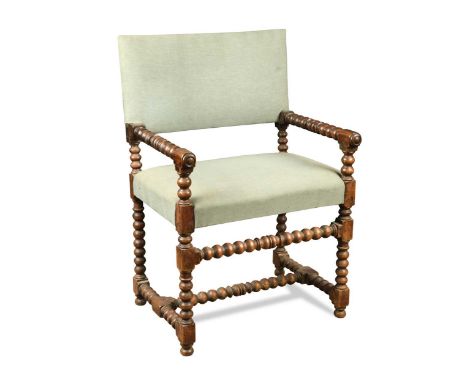 A walnut bobbin turned armchair, in the late 17th century style, the rectangular padded back and seat upholstered in a light 